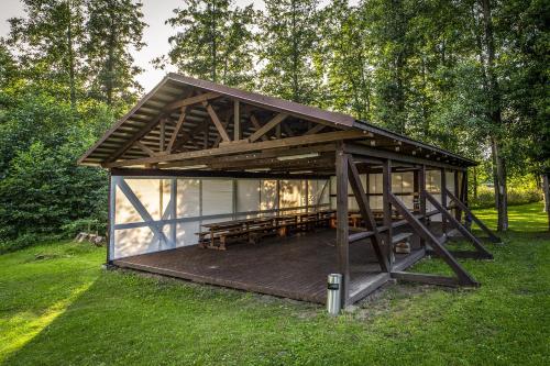 a building with a wooden deck in the grass at Guest House Mednieki in Salainis