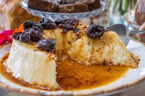 a piece of cake on a plate with a spatula at Green Village Hotel in Monte Verde