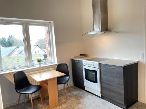 a kitchen with a table and chairs and a stove at rooms for rent Andersen Invest in Skjern