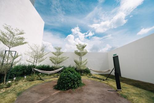 a room with two hammocks and a wall with trees at METROPOL SERVICED APARTMENT at Bukit Mertajam, Pulau Pinang in Bukit Mertajam