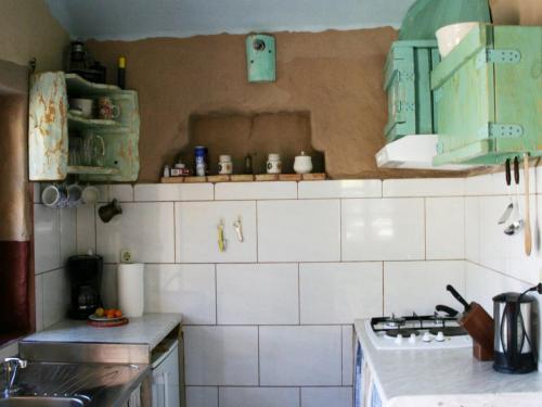a kitchen with green and white tiled walls and a stove at Sage House in Trpanj