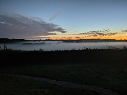 a foggy field with the sunset in the background at Haus Eufalia in Blankenheim