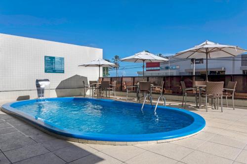 馬塞約的住宿－Marinas Maceió Hotel，一个带椅子和遮阳伞的大型蓝色游泳池