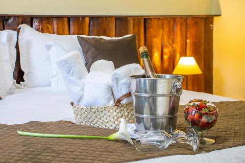 a basket of towels and a bottle of wine on a bed at Green Village Hotel in Monte Verde