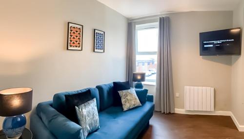 Sofá azul en la sala de estar con ventana en Nap Bristol East en Bristol