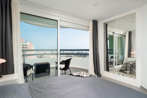 Schlafzimmer mit einem Bett und Blick auf einen Balkon in der Unterkunft Vista Bonita with views on the ocean and the hills in Portimão