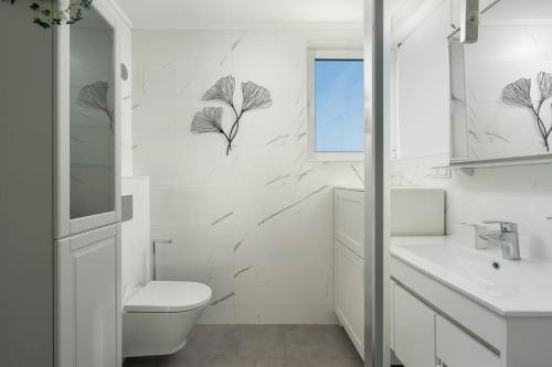 a white bathroom with a toilet and a sink at Vista Bonita with views on the ocean and the hills in Portimão