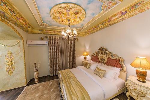 a bedroom with a king sized bed with a coffered ceiling at Hotel Empire Albania in Durrës