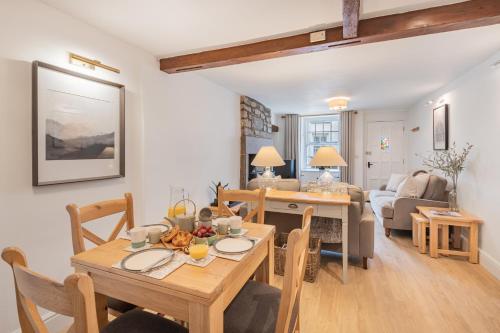 - une salle à manger et un salon avec une table et des chaises dans l'établissement Weavers Cottage, Sleeps 4, town centre, à Kirkby Lonsdale