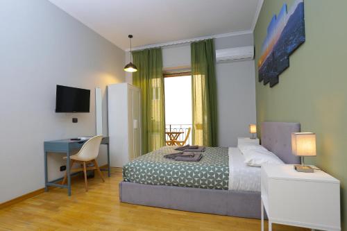 Schlafzimmer mit einem Bett, einem Schreibtisch und einem TV in der Unterkunft Vomero Maison in Neapel