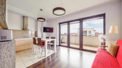 a kitchen and living room with a red couch and a table at Foka, Sun & Snow in Hel