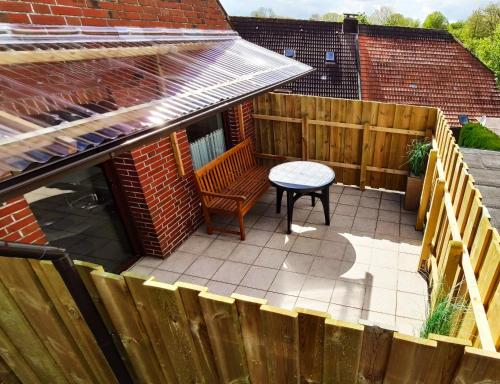 a patio with a table and a wooden fence at Nordsee Ferienwohnung Nord in Dornumersiel