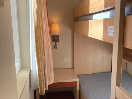 Cette petite chambre comprend des lits superposés et un bureau. dans l'établissement Studio à Saint-Raphaël avec terrasse et piscine - FR-1-504-609, à Saint-Raphaël