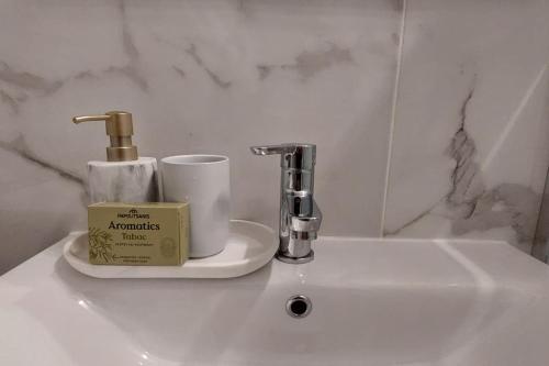 a bathroom sink with a candle and a faucet at Διαμέρισμα studioJoy4stay στο Χαλάνδρι in Athens