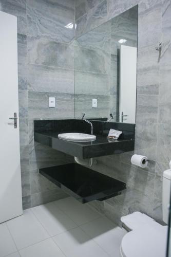 a bathroom with a sink and a mirror at La Suite Praia Hotel in Caucaia