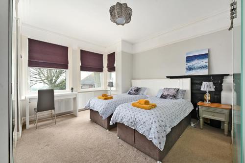een slaapkamer met 2 bedden en een bureau bij NORTHRISE RETREAT in Hastings