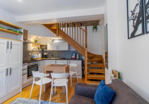a living room with a couch and a kitchen at Talbot Lane Cottage Horsham By My Getaways in Horsham