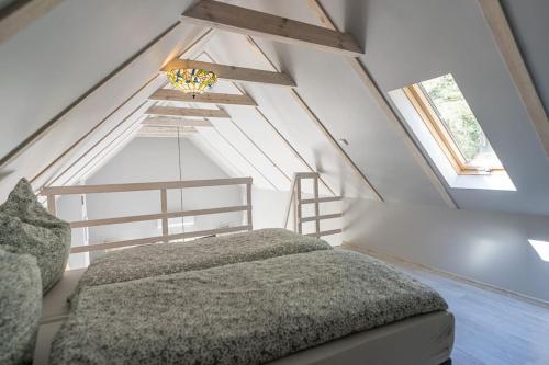 um quarto com uma cama e duas janelas em Wrzosowe Wzgórze - Domek wiejski em Kłaczno