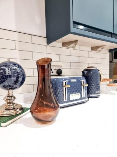 a vase sitting on top of a kitchen counter at Gorgeous Newly Renovated 2 Double Bed Flat in Swansea