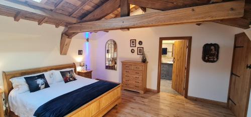 um quarto com uma cama grande e um tecto de madeira em Dom Peyreton Prestige cottages set in a charming wine property em Villegouge