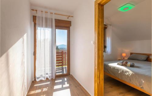 um quarto com uma cama e uma grande janela em Cozy Home In Perusic With Jacuzzi em Perušić