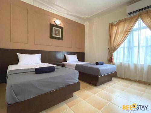 a bedroom with two beds and a window at Afamosa Villa with private pool by BeeStay in Kampong Alor Gajah