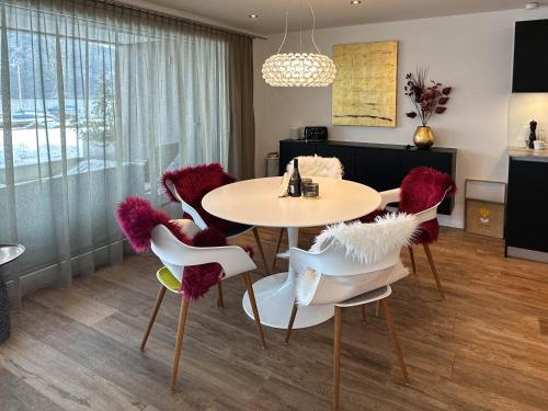 uma sala de jantar com uma mesa e cadeiras com assentos roxos em Nautica em Faulensee