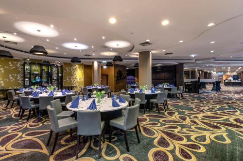 a dining room with tables and chairs and a carpet at Mercure Warszawa Centrum in Warsaw