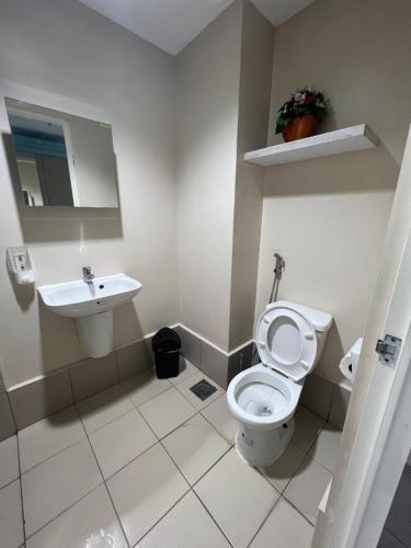 een badkamer met een toilet en een wastafel bij SunVida Tower in Cebu City