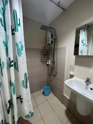 een badkamer met een douchegordijn en een wastafel bij SunVida Tower in Cebu City