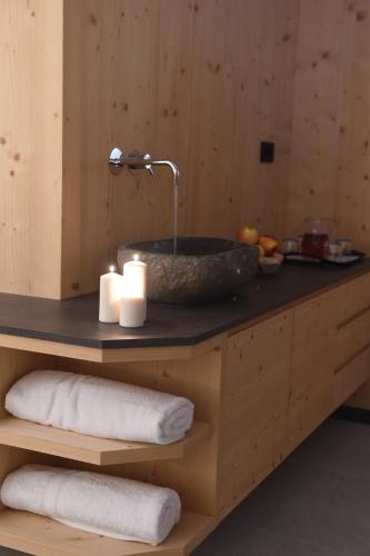 a bathroom with a stone sink with two candles at Les Ciases Chalets Dolomites in San Vigilio Di Marebbe