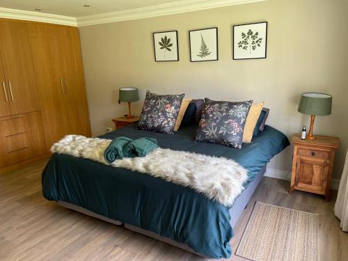 a bedroom with a bed with a blue blanket and pillows at Country living in the City in Midrand