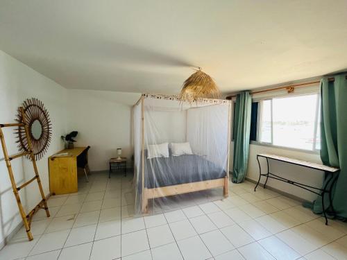 um quarto com uma cama e uma rede mosquiteira em La Cabane du Pêcheur Atlantic Evasion em Dakar