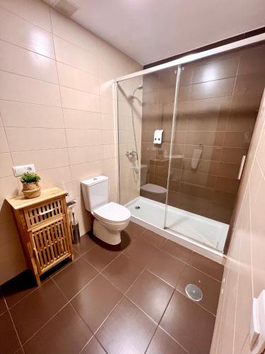 a bathroom with a toilet and a glass shower at Apartamento Sorolla Center in Ayamonte