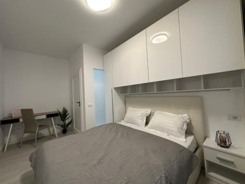 a bedroom with a bed with white cabinets and a desk at Luxury New Apartments Centru in Iaşi