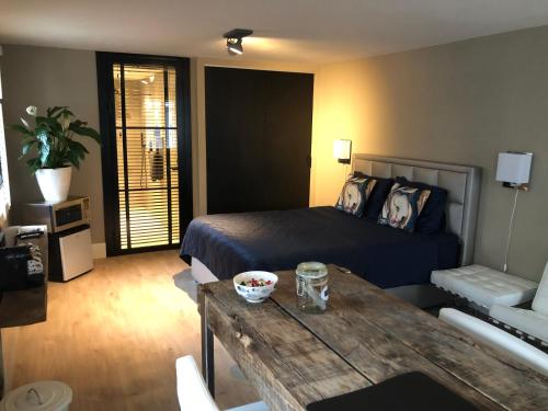 een slaapkamer met een bed en een tafel in een kamer bij B&B de Nieuwe Haven in Bunschoten