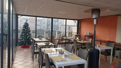 ein Restaurant mit Tischen und einem Weihnachtsbaum in einem Zimmer in der Unterkunft Hotel Antiche Terme Benevento in Benevento