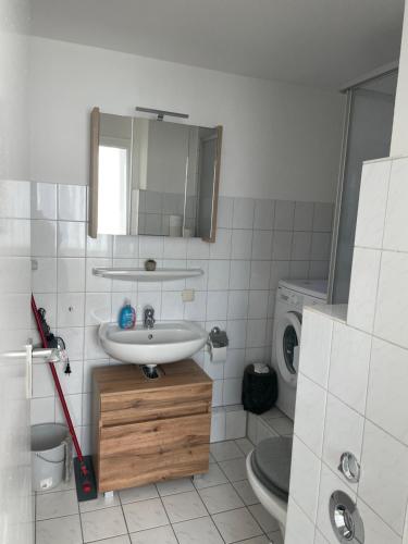a bathroom with a sink and a washing machine at Schickes 2 Zimmer-Cityapartment Bielefeld Mitte in Bielefeld
