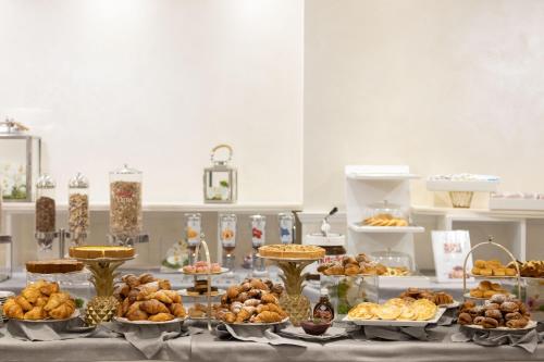a table with many different types of pastries on it at Hotel Sporting in Rimini
