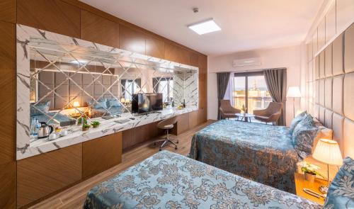 a hotel room with two beds and a tv at Novel Centre Point Hotel in Famagusta