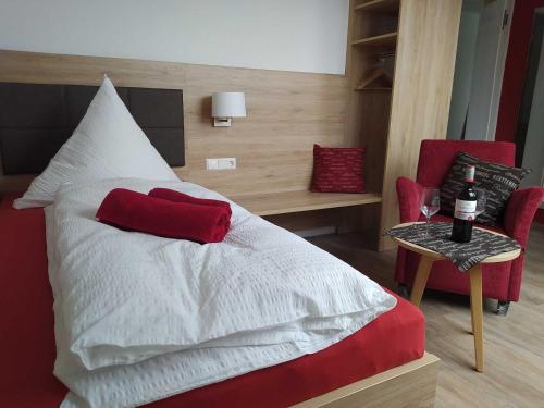 a bedroom with a bed with a red pillow on it at Gästehaus Winzerhof am Schlierbach in Weiler bei Weinsberg