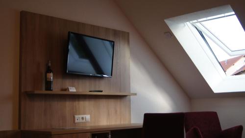 a television on a shelf in a room with a window at Gästehaus Winzerhof am Schlierbach in Weiler bei Weinsberg