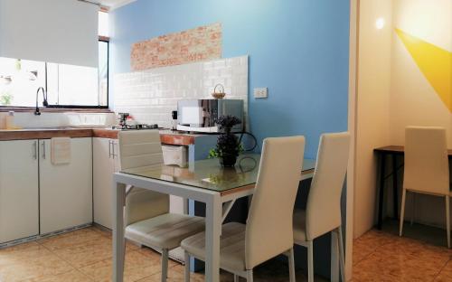 a kitchen with a table with chairs and a microwave at Casa Samaykuy in Ayacucho
