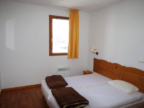 a bedroom with a bed with white sheets and a window at Appartement Le Dévoluy, 3 pièces, 6 personnes - FR-1-504-497 in Superdevoluy