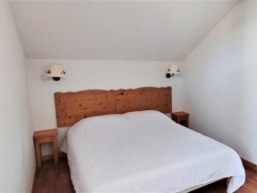 a bedroom with a white bed with two lights on the wall at Chalet Le Dévoluy, 3 pièces, 6 personnes - FR-1-504-493 in Superdevoluy