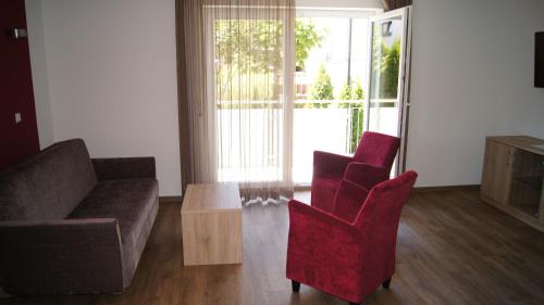 a living room with a couch and two chairs and a table at Gästehaus Winzerhof am Schlierbach in Weiler bei Weinsberg