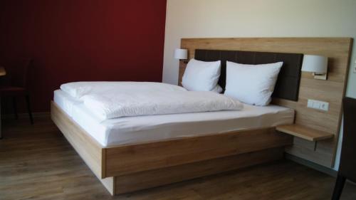 a bedroom with a bed with a wooden headboard at Gästehaus Winzerhof am Schlierbach in Weiler bei Weinsberg