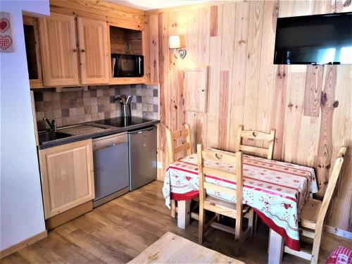 une cuisine avec une table et des chaises ainsi qu'une cuisine avec une cuisinière dans l'établissement Duplex rénové 4 pers. avec terrasse - Résidence Les Chalets d'Aurouze, La Joue du Loup - FR-1-504-553, à Saint-Étienne-en-Dévoluy