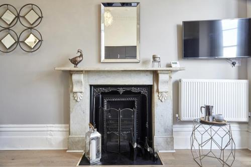 a living room with a fireplace and a tv at nap Bristol Clifton in Bristol