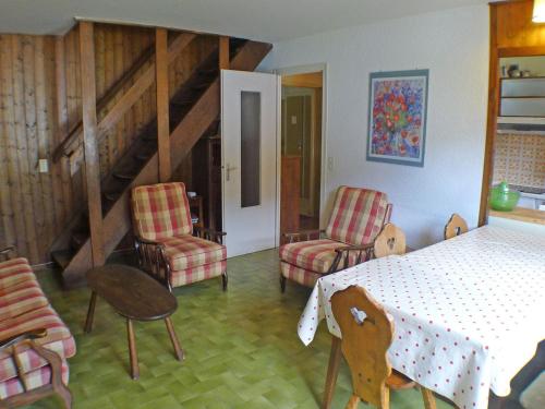 une pièce avec une table, des chaises et un escalier dans l'établissement Duplex 4 pièces à Samoëns avec balcon et WiFi inclus - FR-1-629-3, à Samoëns